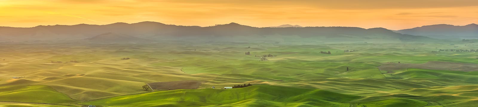 Hills and mountains in the distance at sunset.